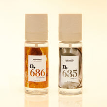 Two bottles of 'noteworthy' cologne with labels showing numbers on a beige background